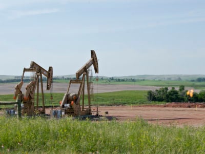 Two drills pump the ground for oil as moisture flares up in the separator.