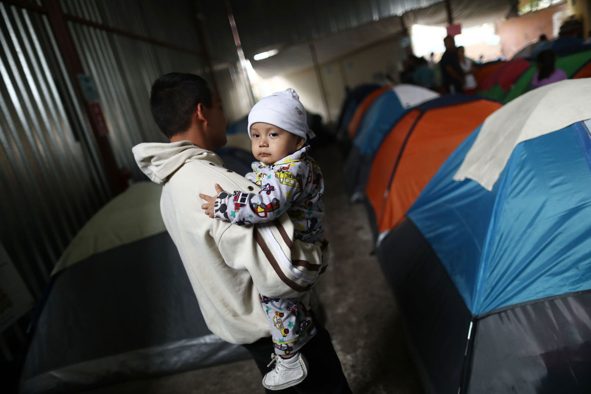 A father from Guatemala carries his son in the migrant shelter where they are currently living near the U.S.-Mexico border on April 4, 2019, in Tijuana, Mexico. Many staying at the shelter are hoping for political asylum in the U.S.