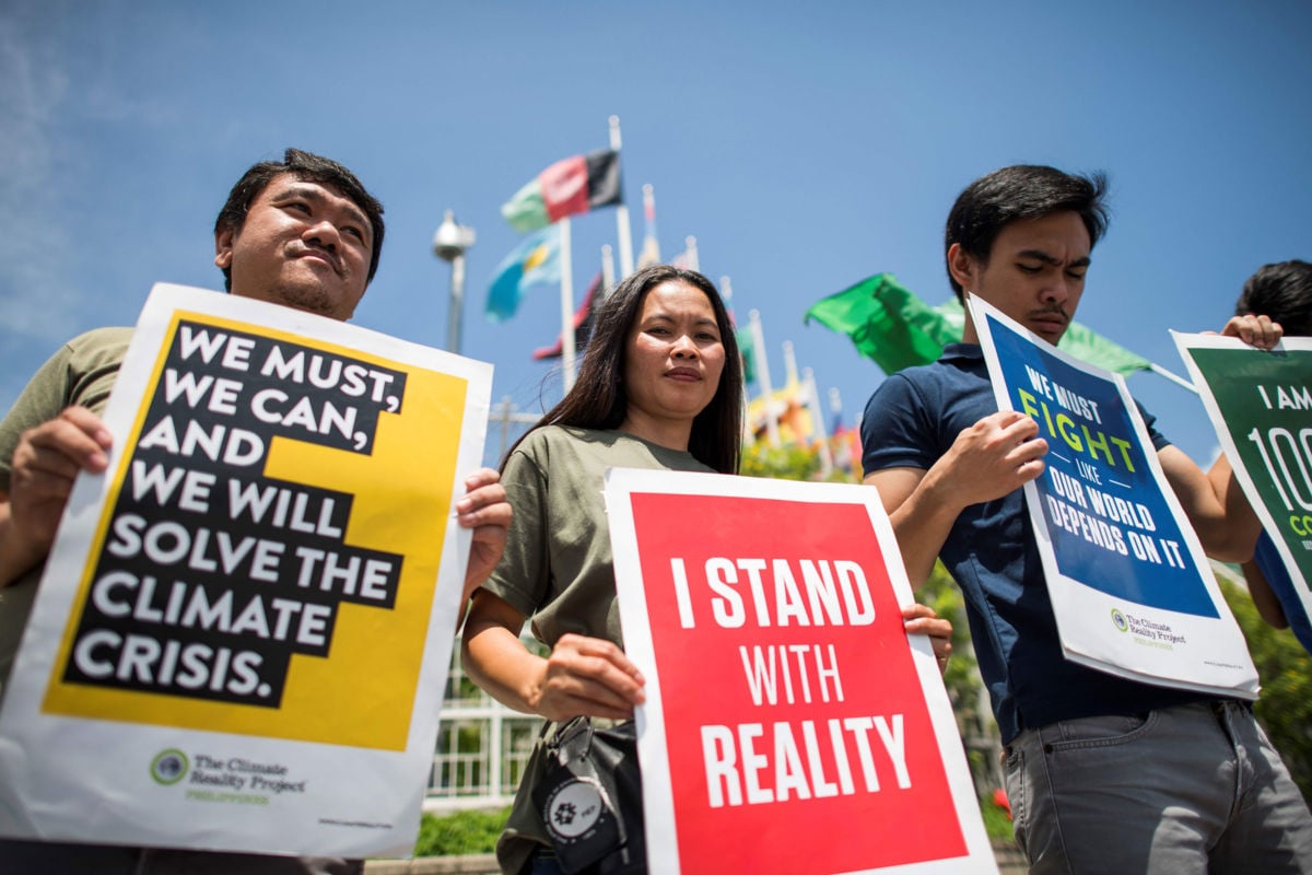 Environmental activists display placards during a demonstration in front of the United Nations building in Bangkok on September 7, 2018.