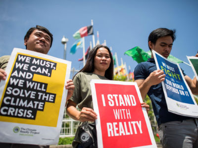 Environmental activists display placards during a demonstration in front of the United Nations building in Bangkok on September 7, 2018.