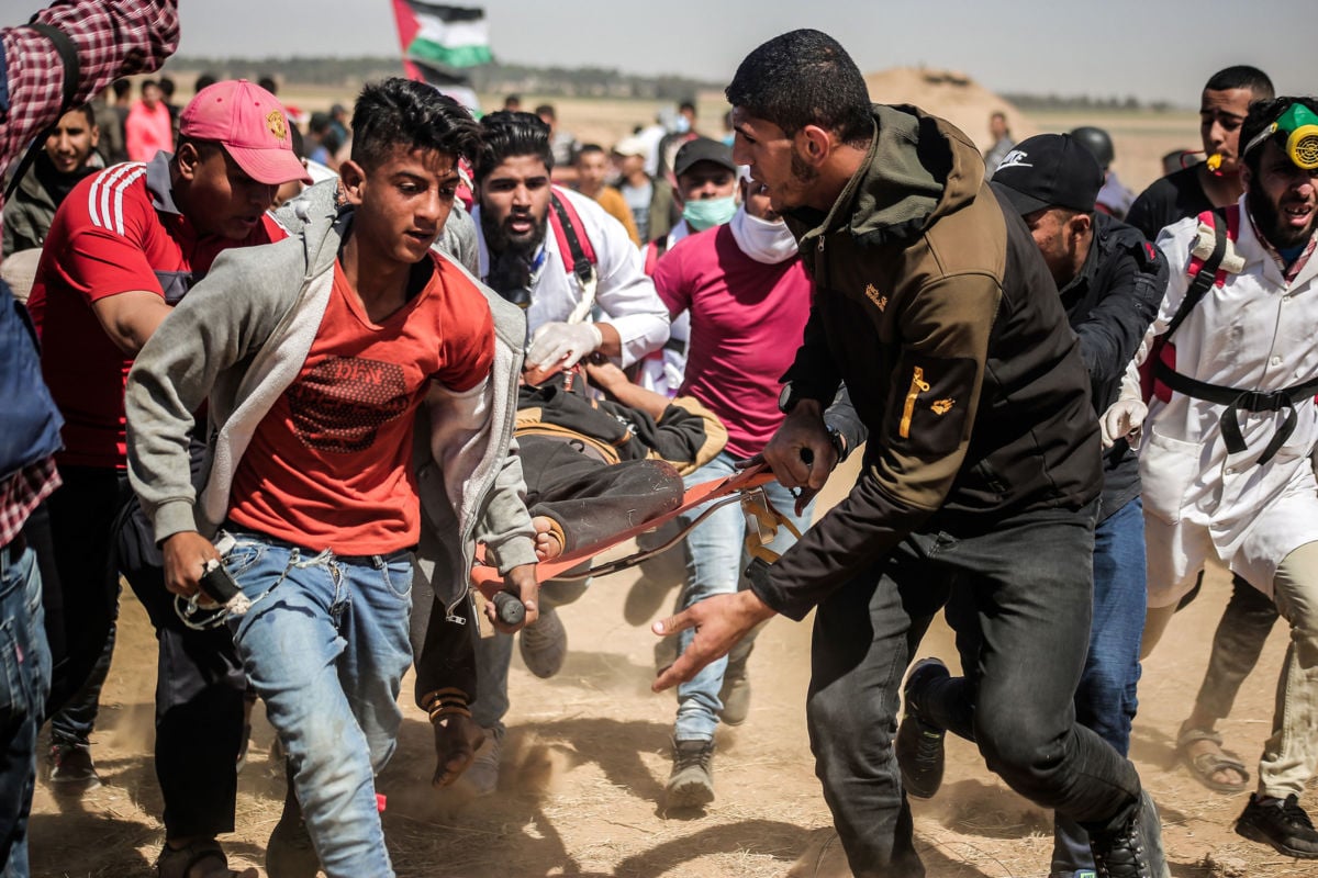 Palestinian medics are seen carrying a wounded staff member during a demonstration to mark the 71st anniversary of Nakba Day, May 15, 2019.