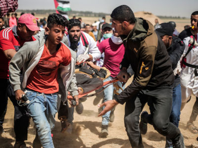 Palestinian medics are seen carrying a wounded staff member during a demonstration to mark the 71st anniversary of Nakba Day, May 15, 2019.