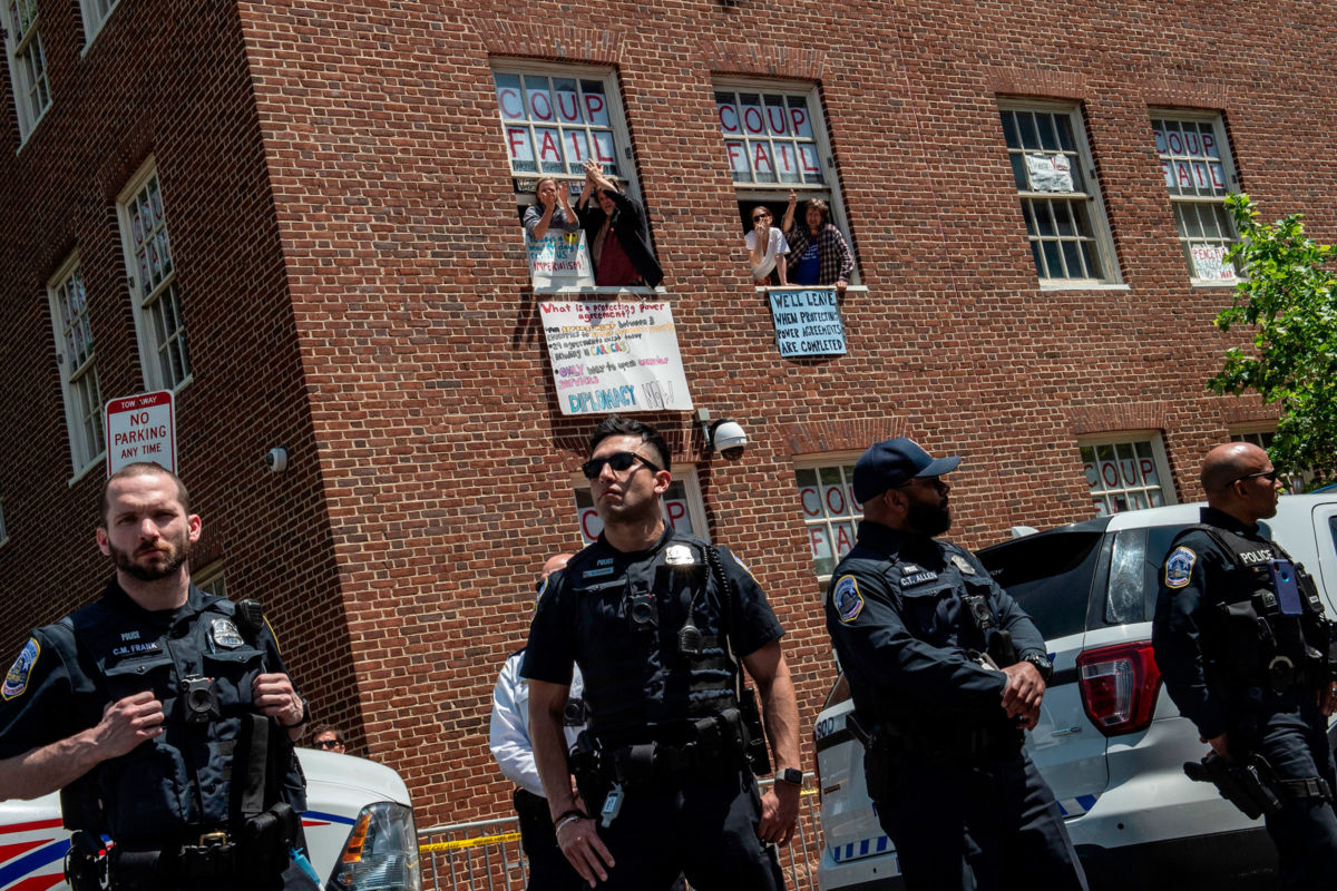 Pro-Nicolás Maduro supporters and activists occupying the Venezuelan embassy in Washington, D.C., wave from a window on May 15, 2019.