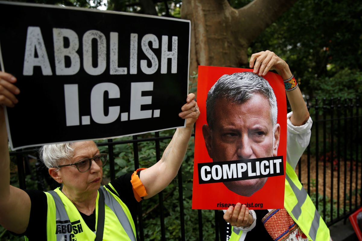 People hold posters of New York City Mayor Bill de Blasio and banners as they gather to stage a demonstration in support of those deported by the Immigration and Customs Enforcement (ICE) division of the Department of Homeland Security offices in front of the New York City Hall in New York, United States, on July 30, 2018.