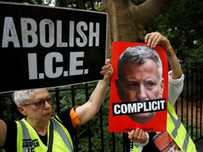 People hold posters of New York City Mayor Bill de Blasio and banners as they gather to stage a demonstration in support of those deported by the Immigration and Customs Enforcement (ICE) division of the Department of Homeland Security offices in front of the New York City Hall in New York, United States, on July 30, 2018.