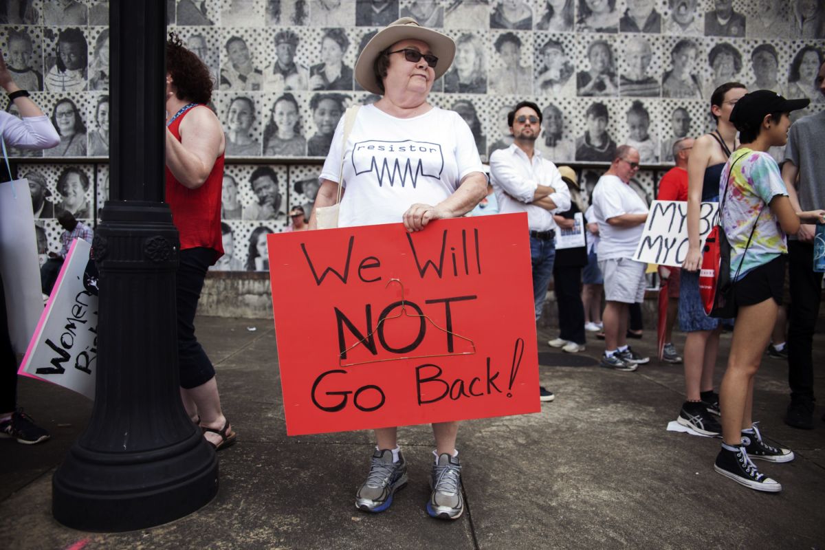 A woman displays a red pro-choice sign during a protest