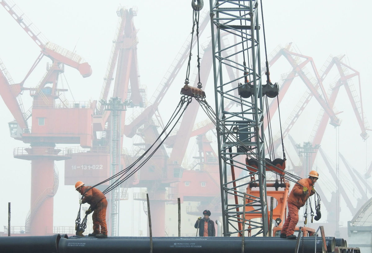 Workers prepare to load pipes onto a ship at the port in Lianyungang, China's eastern Jiangsu province, on January 14, 2019.