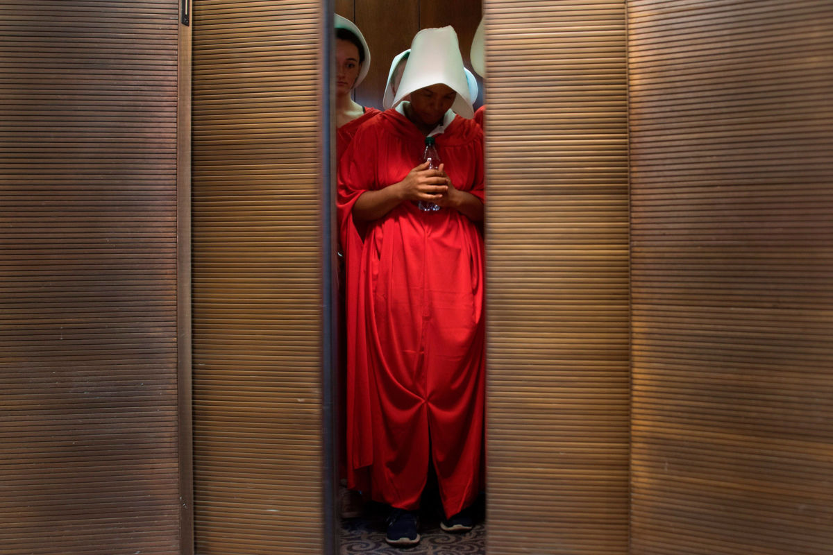Women dressed as characters from the novel-turned-TV series "The Handmaid's Tale" stand in an elevator at the Hart Senate Office Building in Washington D.C. on September 4, 2018.