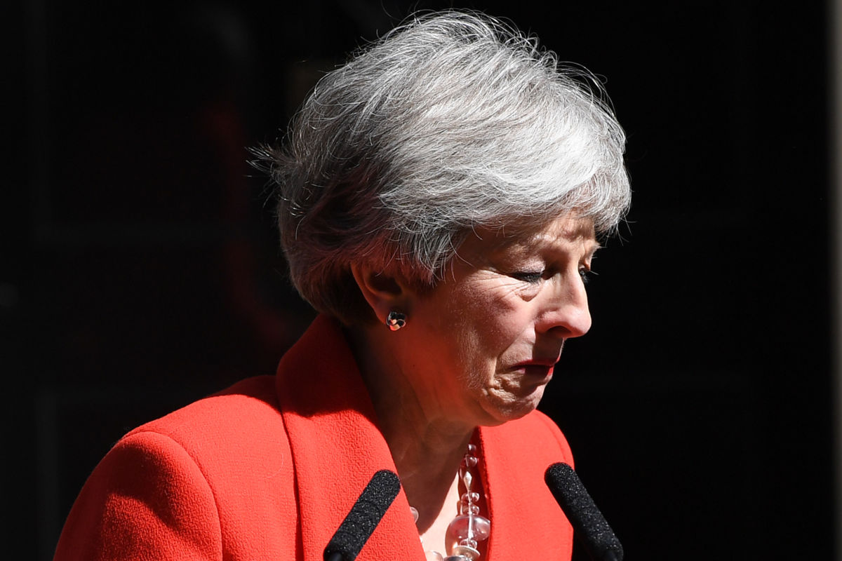 Theresa May cries while wearing a red blazer