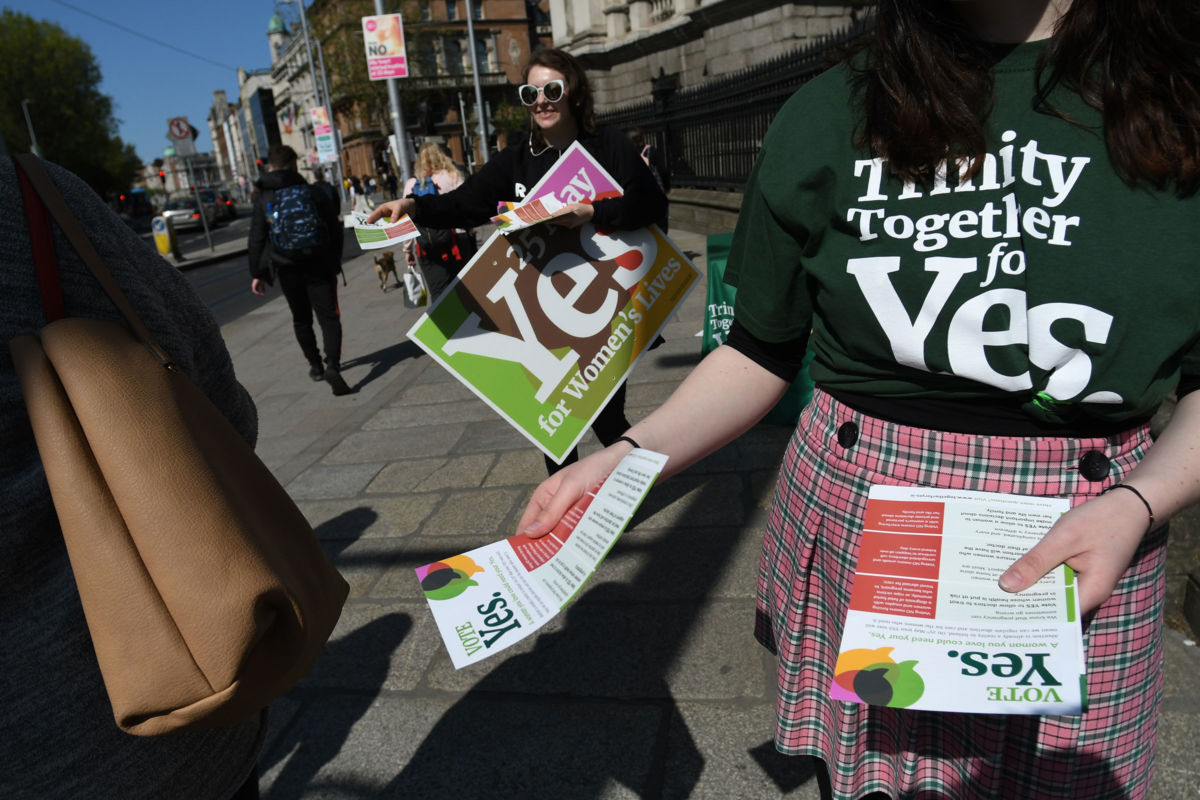 Activists from the 'Trinity Together for Yes' campaign canvass in front of the main entrance to Trinity College in Dublin's City Center on May 16, 2018.