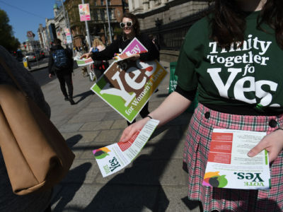 Activists from the 'Trinity Together for Yes' campaign canvass in front of the main entrance to Trinity College in Dublin's City Center on May 16, 2018.