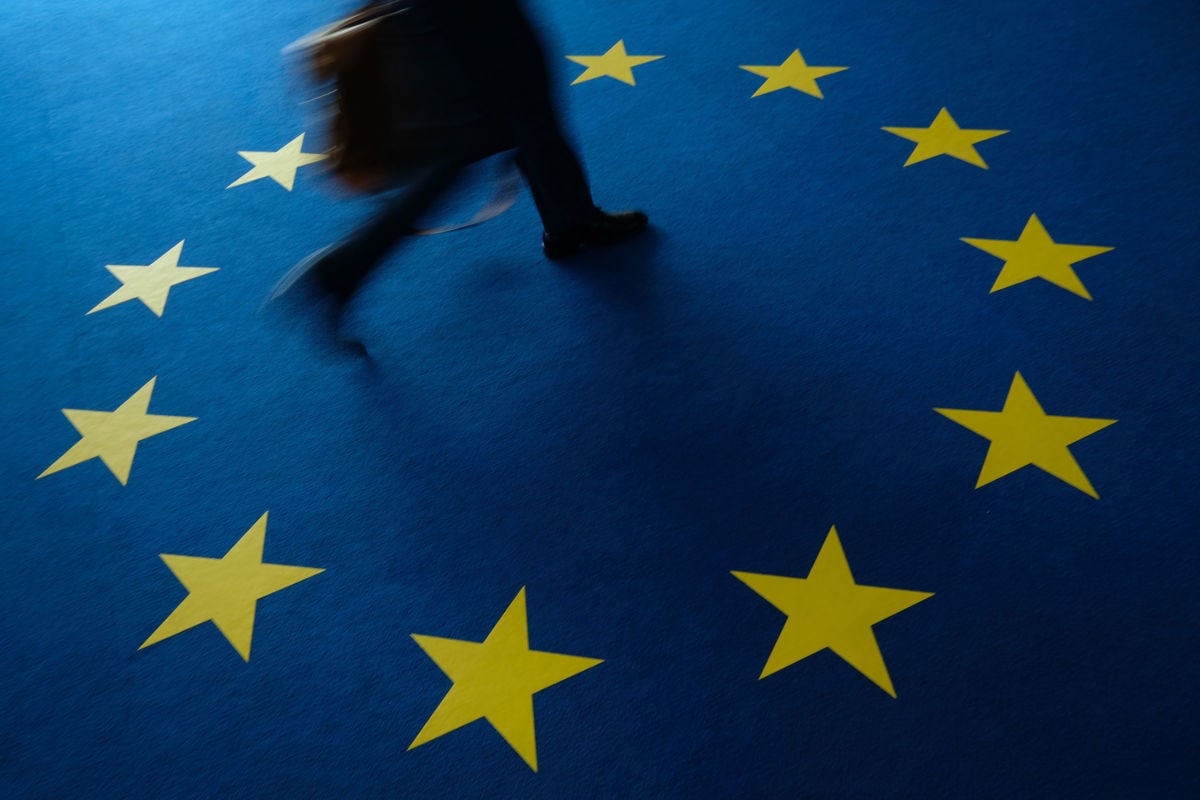 A person walks across carpeting with the flag of the European Union