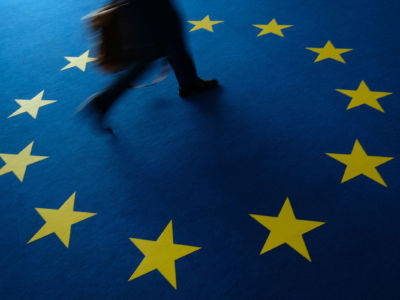 A person walks across carpeting with the flag of the European Union