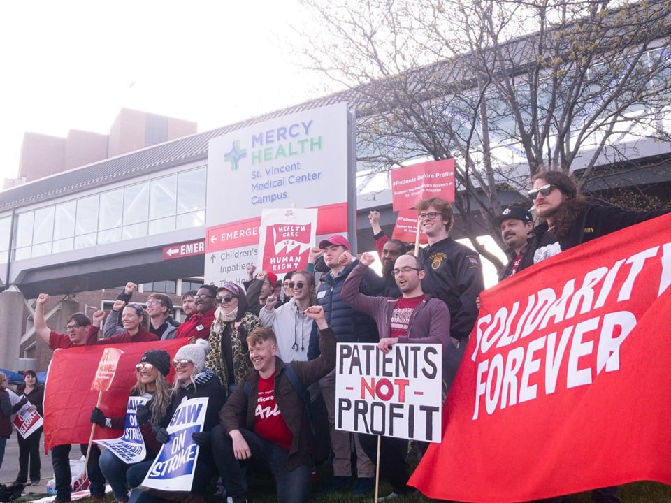 People raise their fists while displaying red signsPeople raise their fists while displaying red pro-union signs