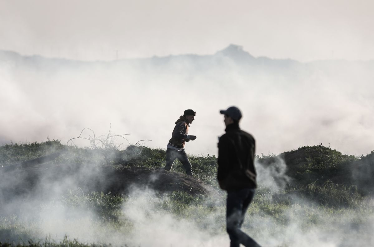 People are seen through a haze of tear gas