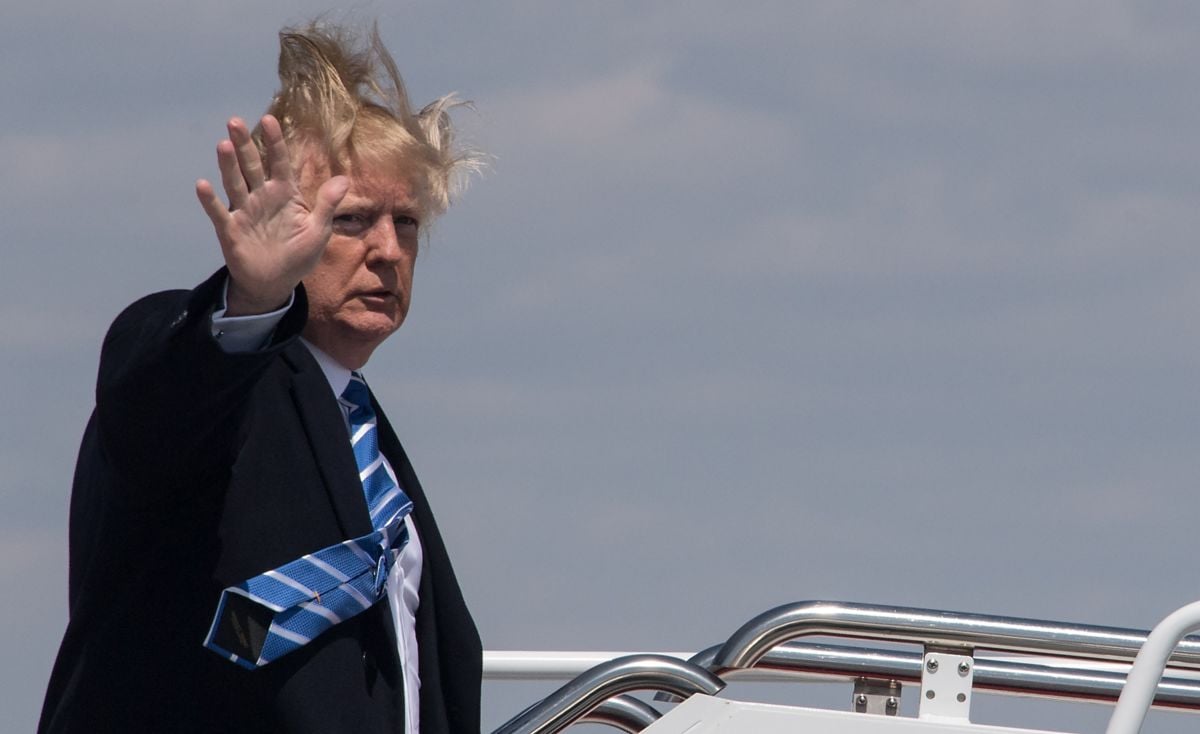 Donald Trump's hair blows in the wind as he boards Air Force One