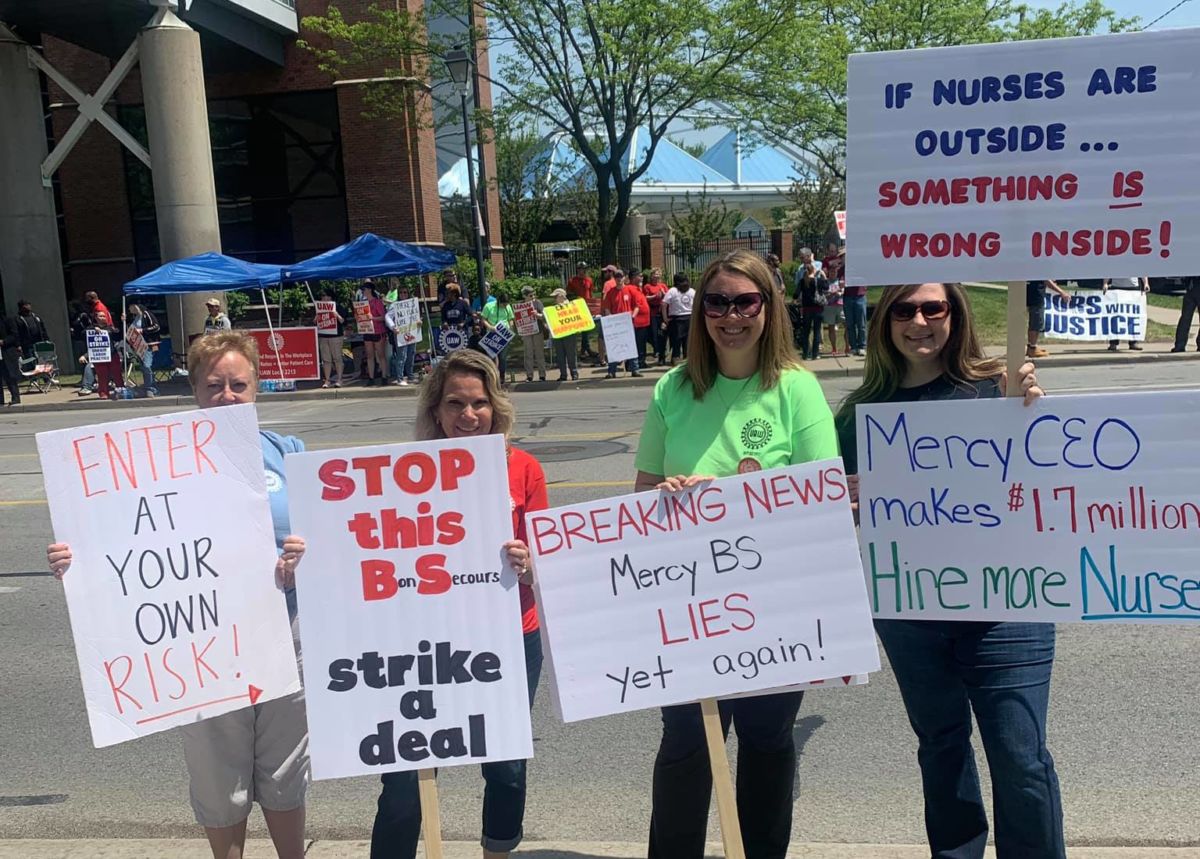 Four nurses display signs supporting their strike
