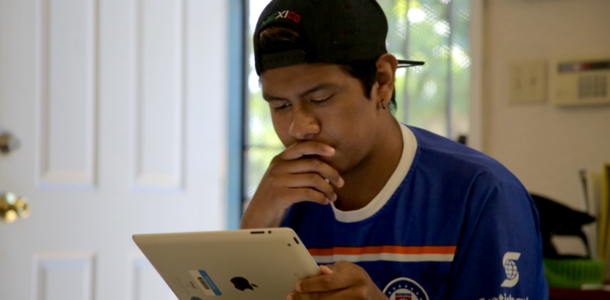 A young man looks down at an ipad