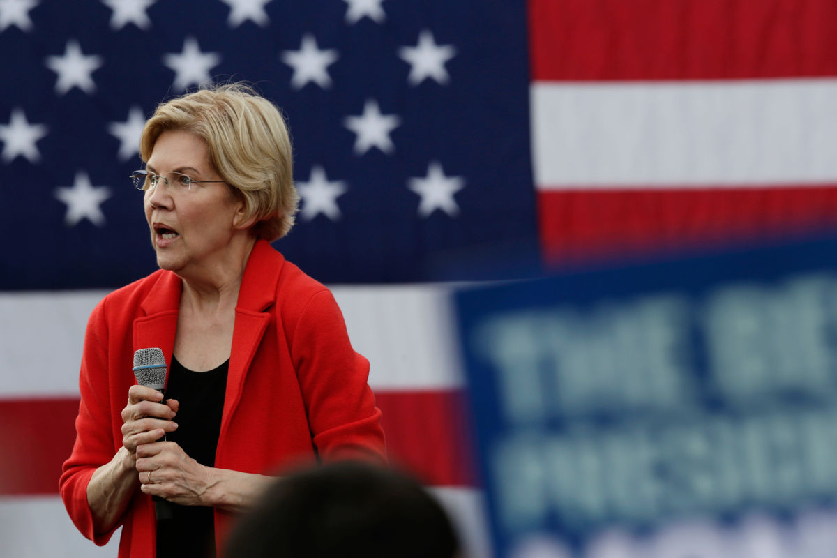 Elizabeth Warren speaks in front of a U.S. flag