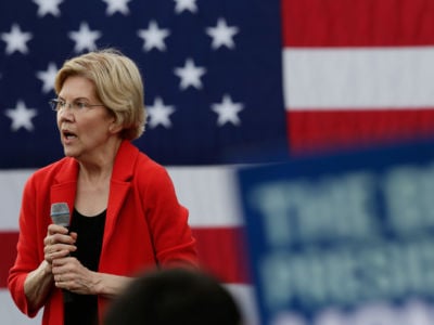 Elizabeth Warren speaks in front of a U.S. flag