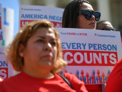 A woman holds a sign reading "EVERY PERSON COUNTS" during a protest, census