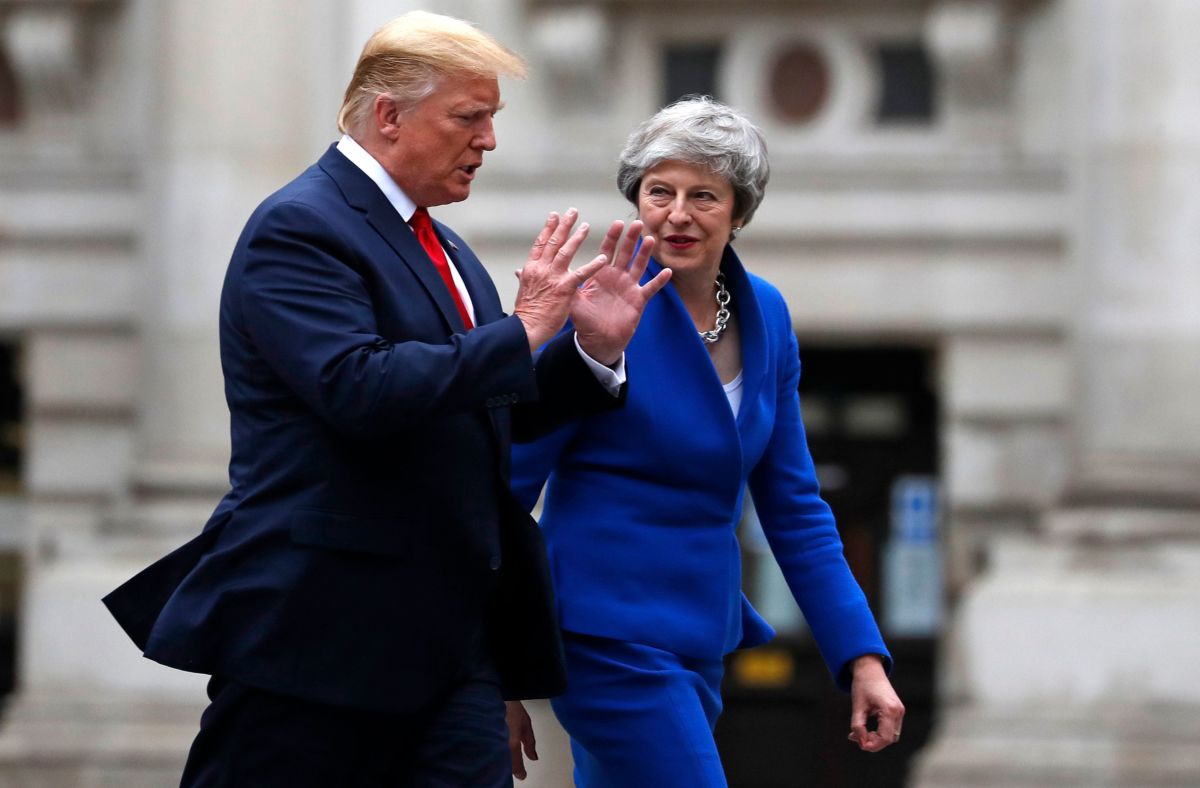 Theresa May and Donald Trump walk side by side while conversing