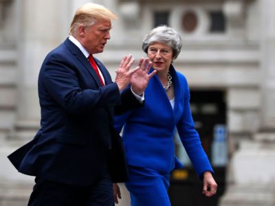 Theresa May and Donald Trump walk side by side while conversing