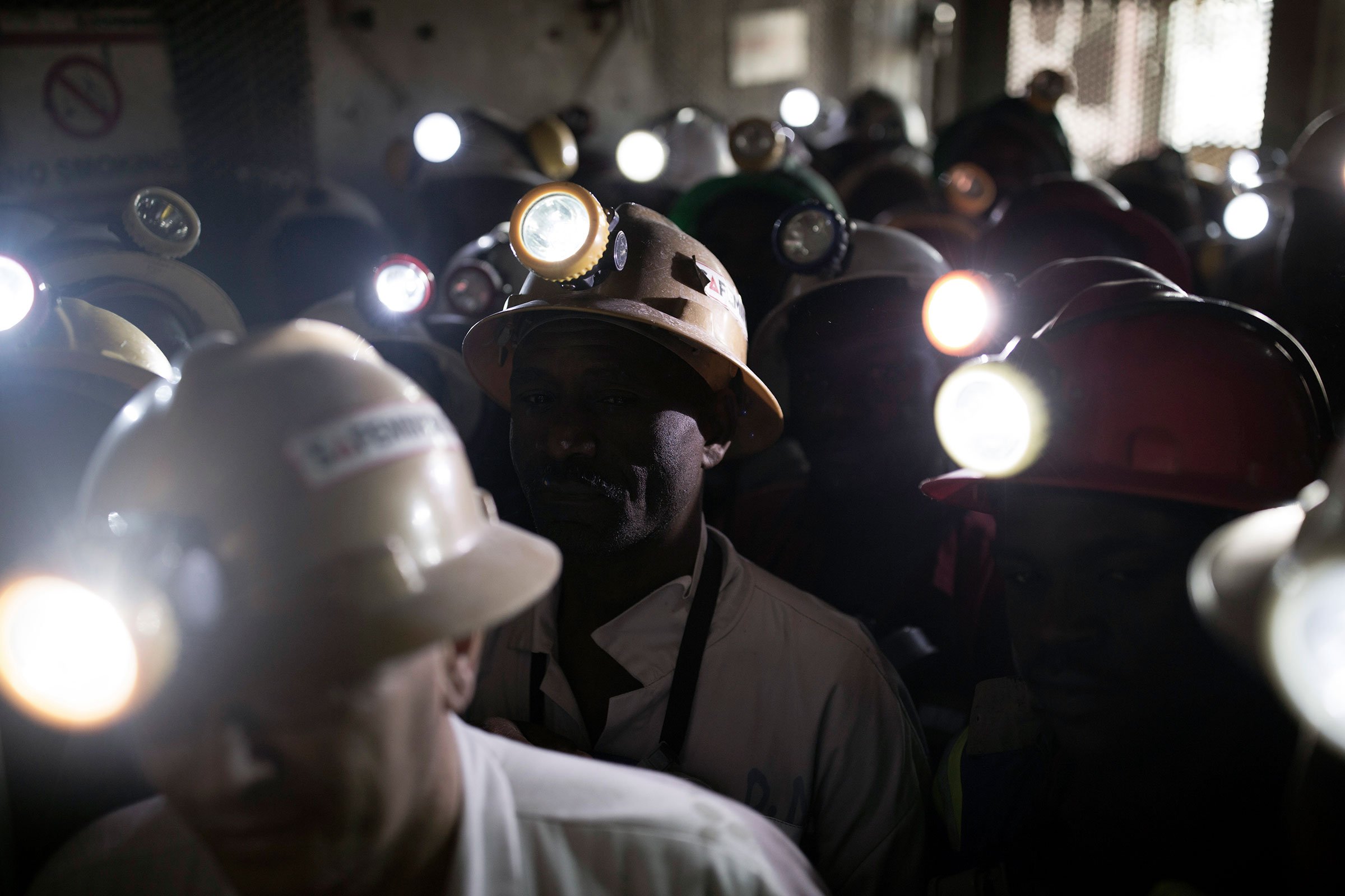 Mine workers wait to descend underground for an 8-hour shift mining copper in one of the shafts at Mopani in Mufulira, Zambia, on July 6, 2016. 
