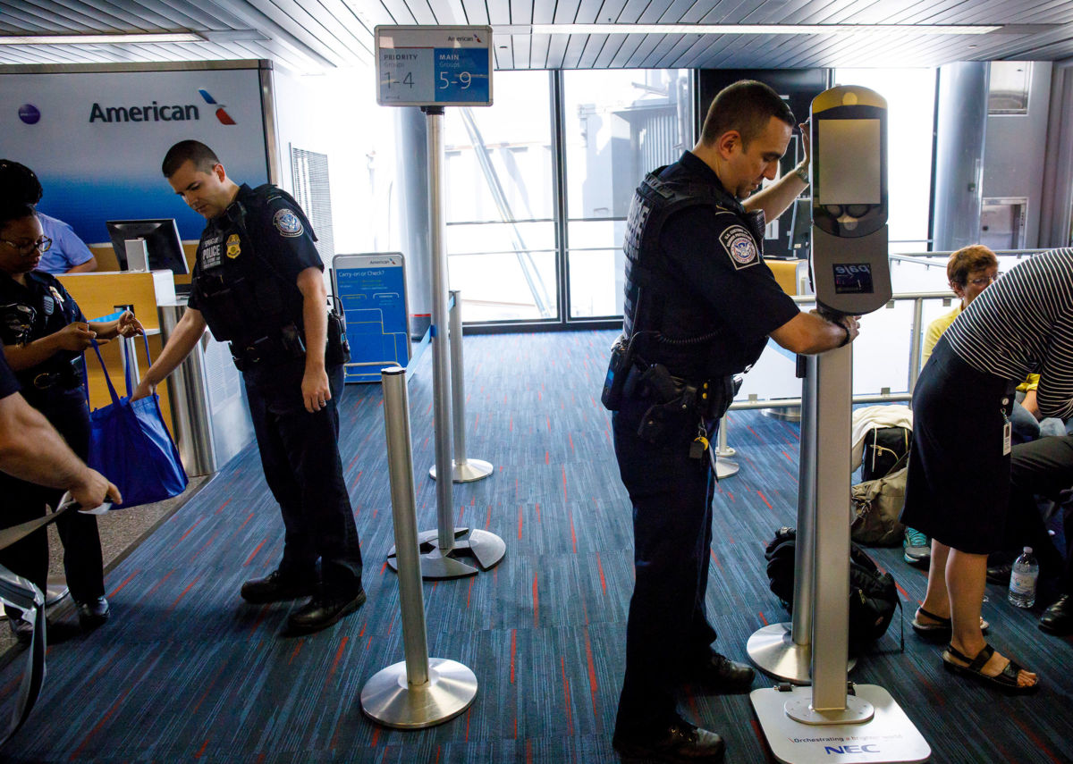 U.S. Customs and Border Protection officers move facial recognition scanners at O'Hare International Airport, July 19, 2017.