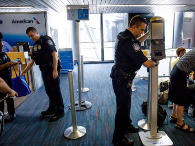 U.S. Customs and Border Protection officers move facial recognition scanners at O'Hare International Airport, July 19, 2017.