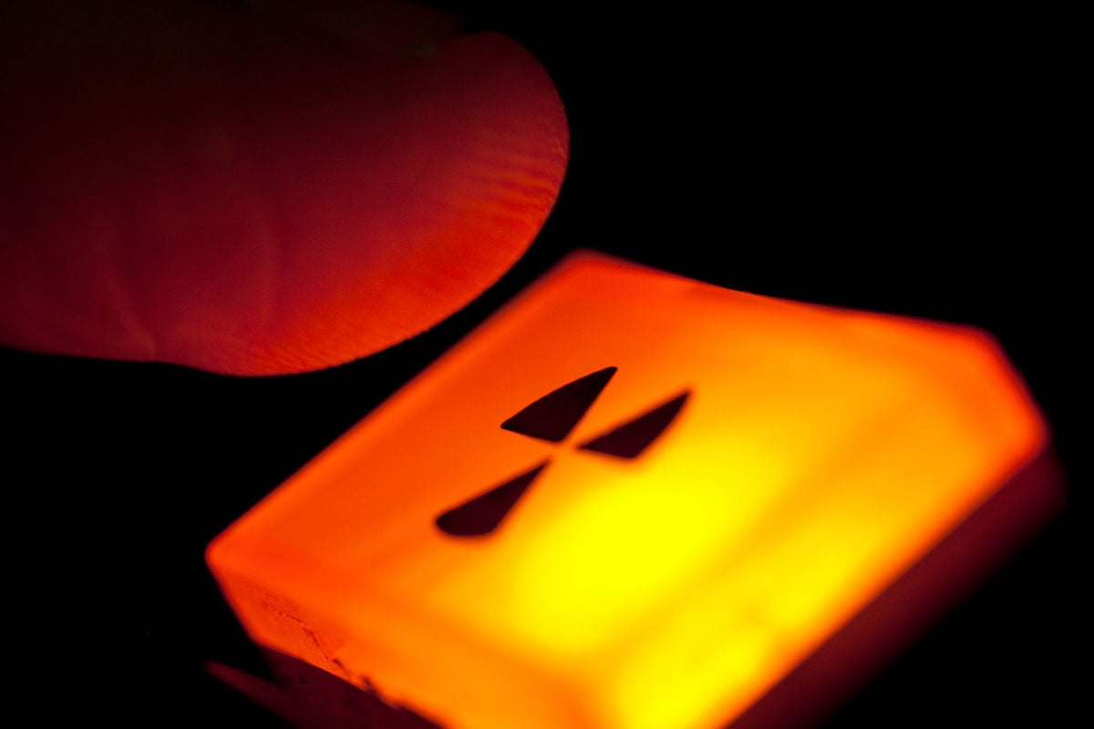 A finger hovers over a glowing orange nuclear button