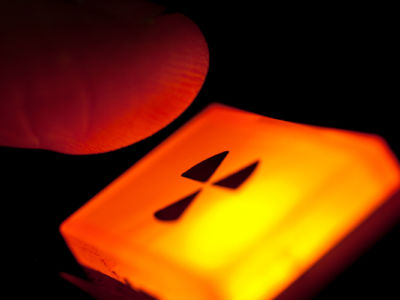 A finger hovers over a glowing orange nuclear button