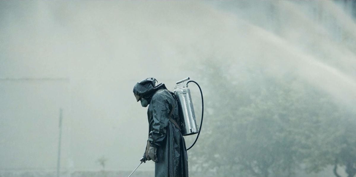 A man in a hazmat suit walks through fog