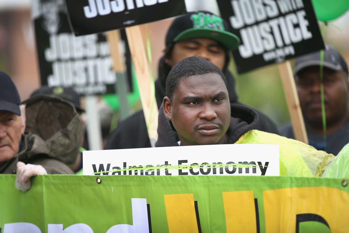 Protesters wearing green shirts demonstrate against Walmart