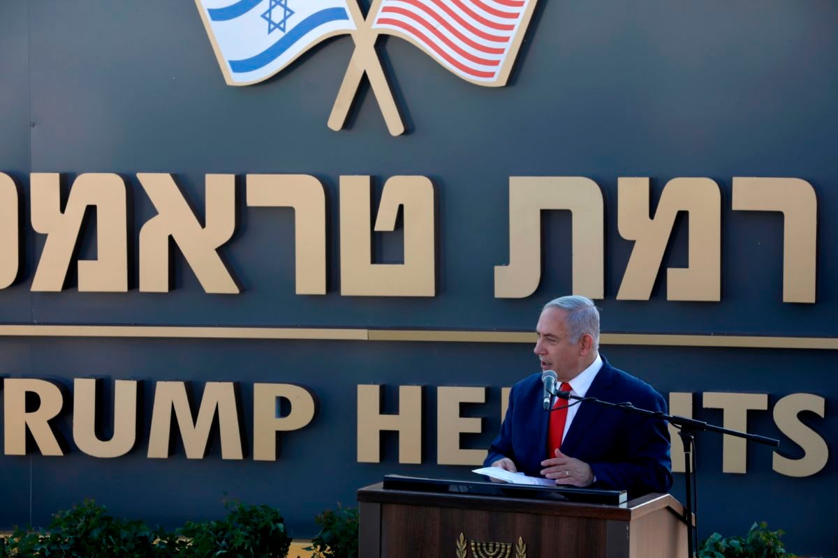 Benjamin Netanyahu stands in front of a sign reading "TRUMP HEIGHTS"