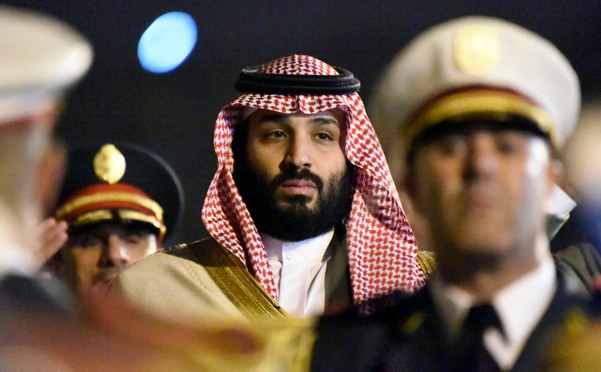 Mohammed Bin Salman walks while being flanked by gaurds