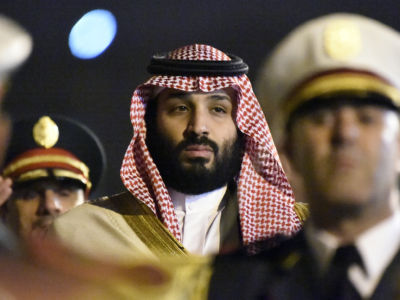 Mohammed Bin Salman walks while being flanked by gaurds