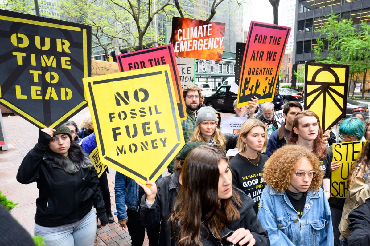 Protesters seen with placards during a Sunrise NYC rally in support of the Green New Deal outside Sen. Chuck Schumer's office on Third Avenue in New York City, April 30, 2019.
