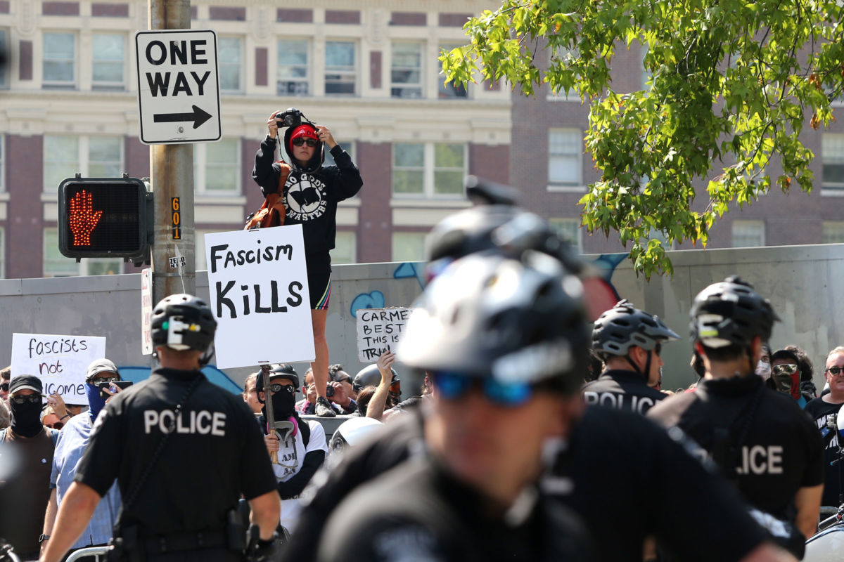 Counter demonstrators blocked by police shout at Joey Gibson, leader of the Patriot Prayer, and other groups as they march through the streets during their rally on August 18, 2018, in Seattle, Washington.