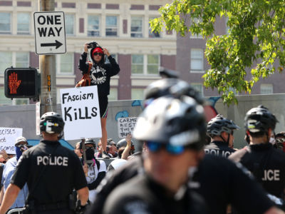 Counter demonstrators blocked by police shout at Joey Gibson, leader of the Patriot Prayer, and other groups as they march through the streets during their rally on August 18, 2018, in Seattle, Washington.