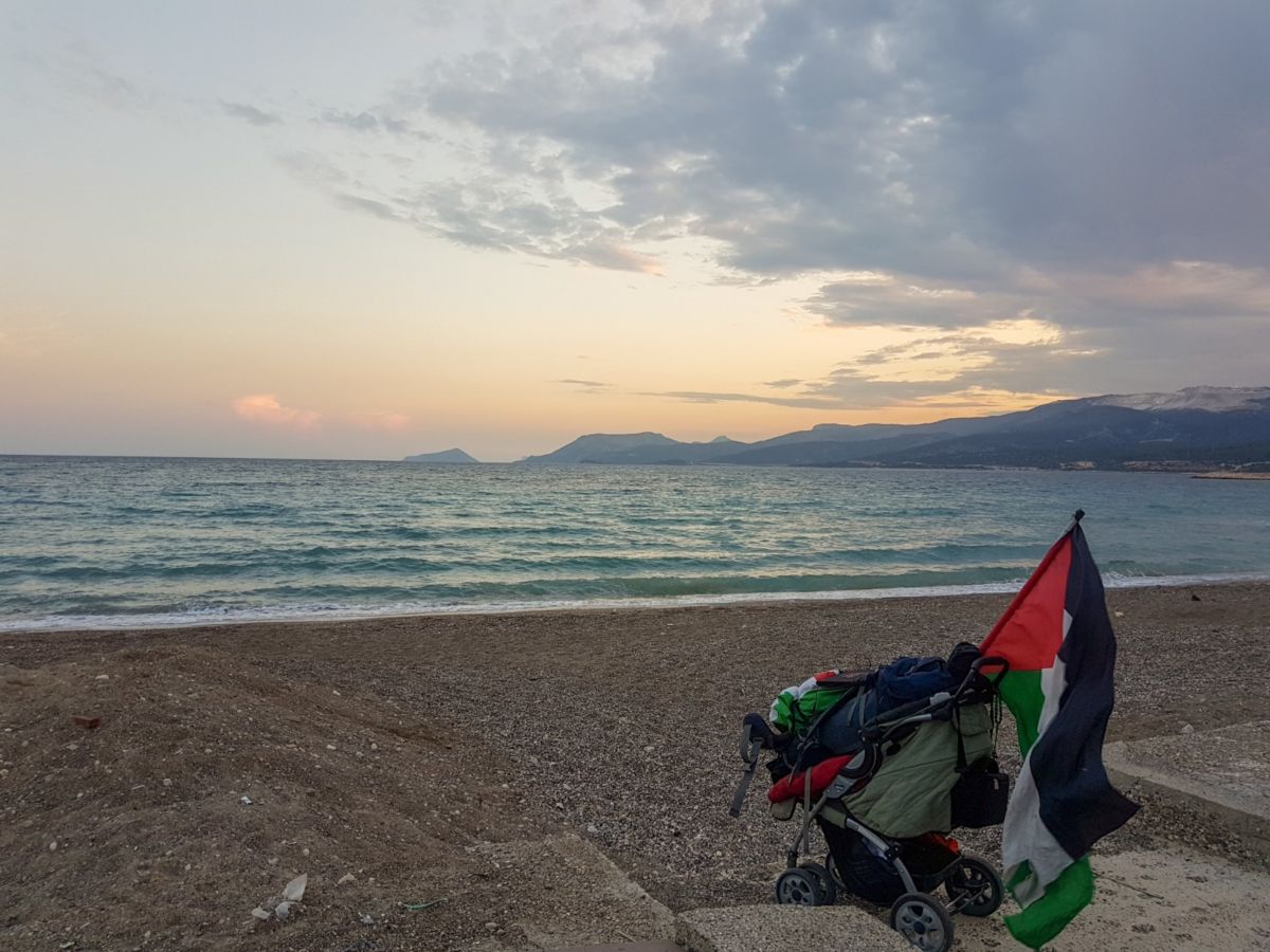 Shortly before boarding a boat to Lebanon, Benjamin Ladraa parks his stroller of luggage and his Palestinian flag on a harbor in Turkey. 