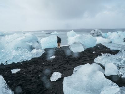 A man takes photos amidst hunks of sea ice