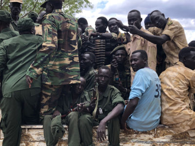 Men in army uniforms pose for a photo