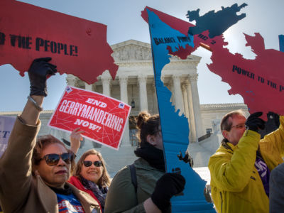 Protesters in front of the U.S. Supreme court building hold cutouts of gerrimandered districts