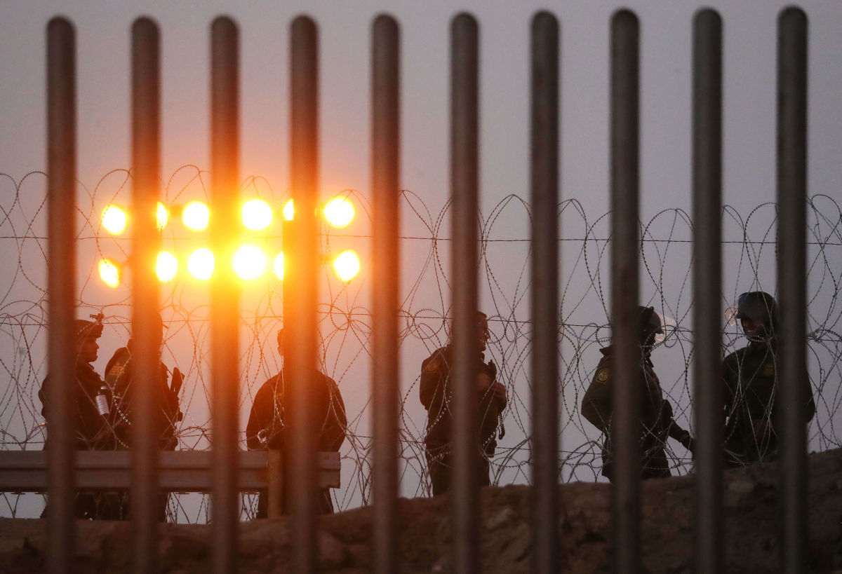 U.S. Border Patrol agents stand watch on the U.S. side of the U.S.-Mexico border fence at dusk on November 26, 2018, in Tijuana, Mexico.