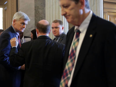 Sen. Bill Cassidy (L) talks with Sen. Chris Coons outside the Senate Chamber at the U.S. Capitol, July 26, 2017, in Washington, D.C. The American Chemistry Council is running ads in support of both senators, who are up for reelection in 2020.