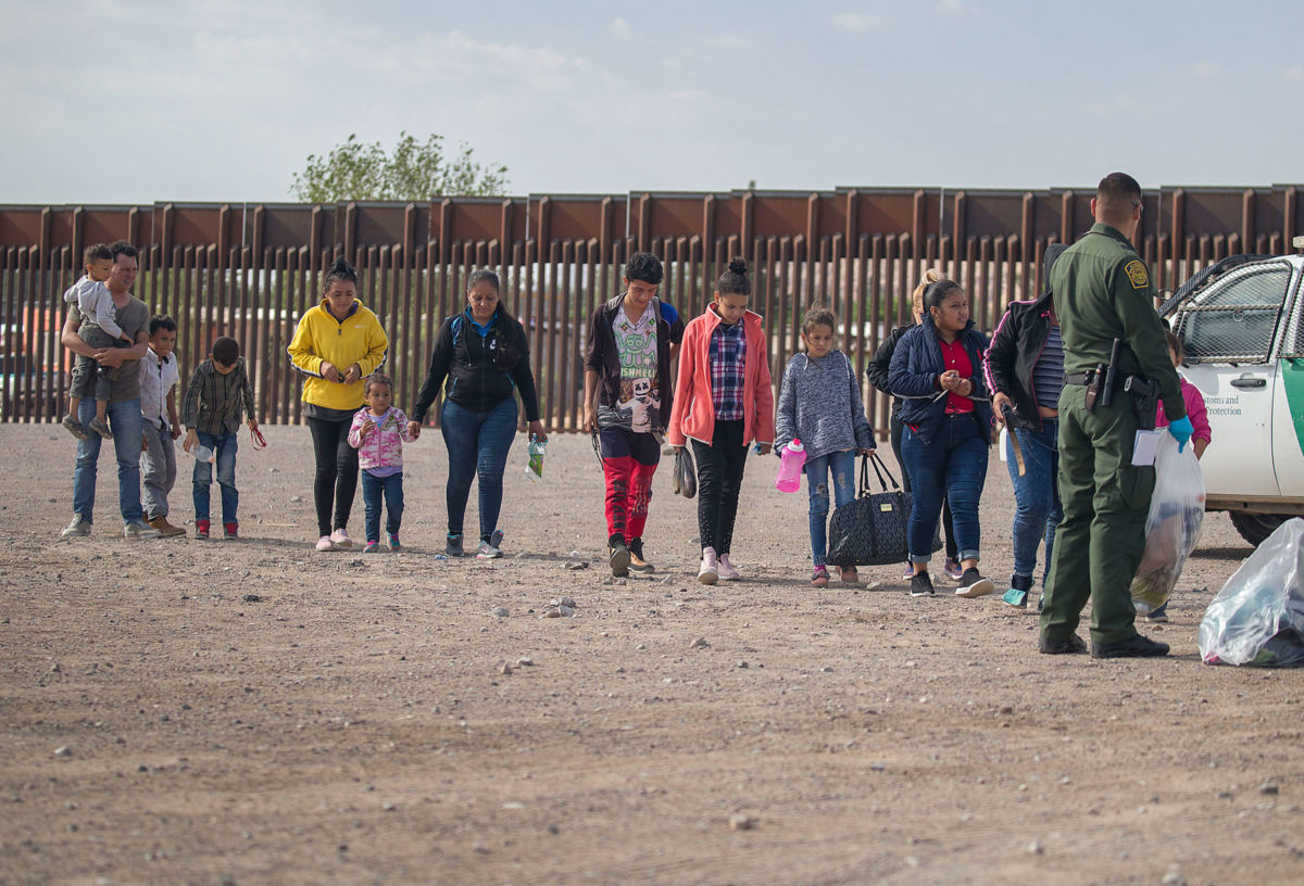 Migrants wait to be processed and loaded onto a bus by Border Patrol agents after being detained after crossing into the United States from Mexico on June 2, 2019, in Sunland Park, New Mexico.