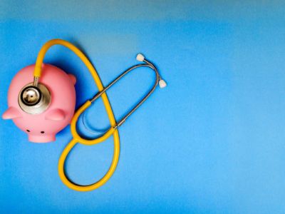 A stethescope rests on a pink piggy bank, healthcare, spending, medicare for all, m4a