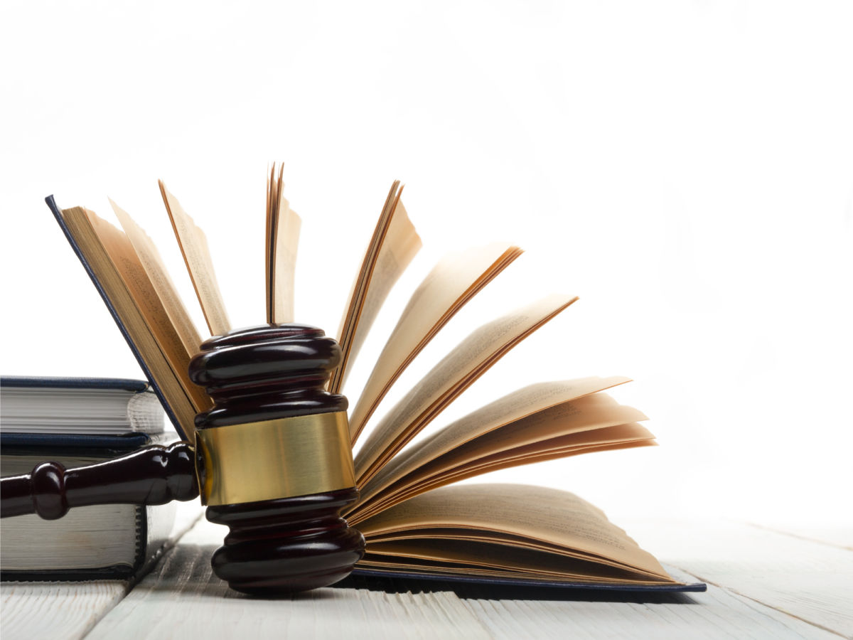 A gavel is seen in front of the spread pages of a book, prison