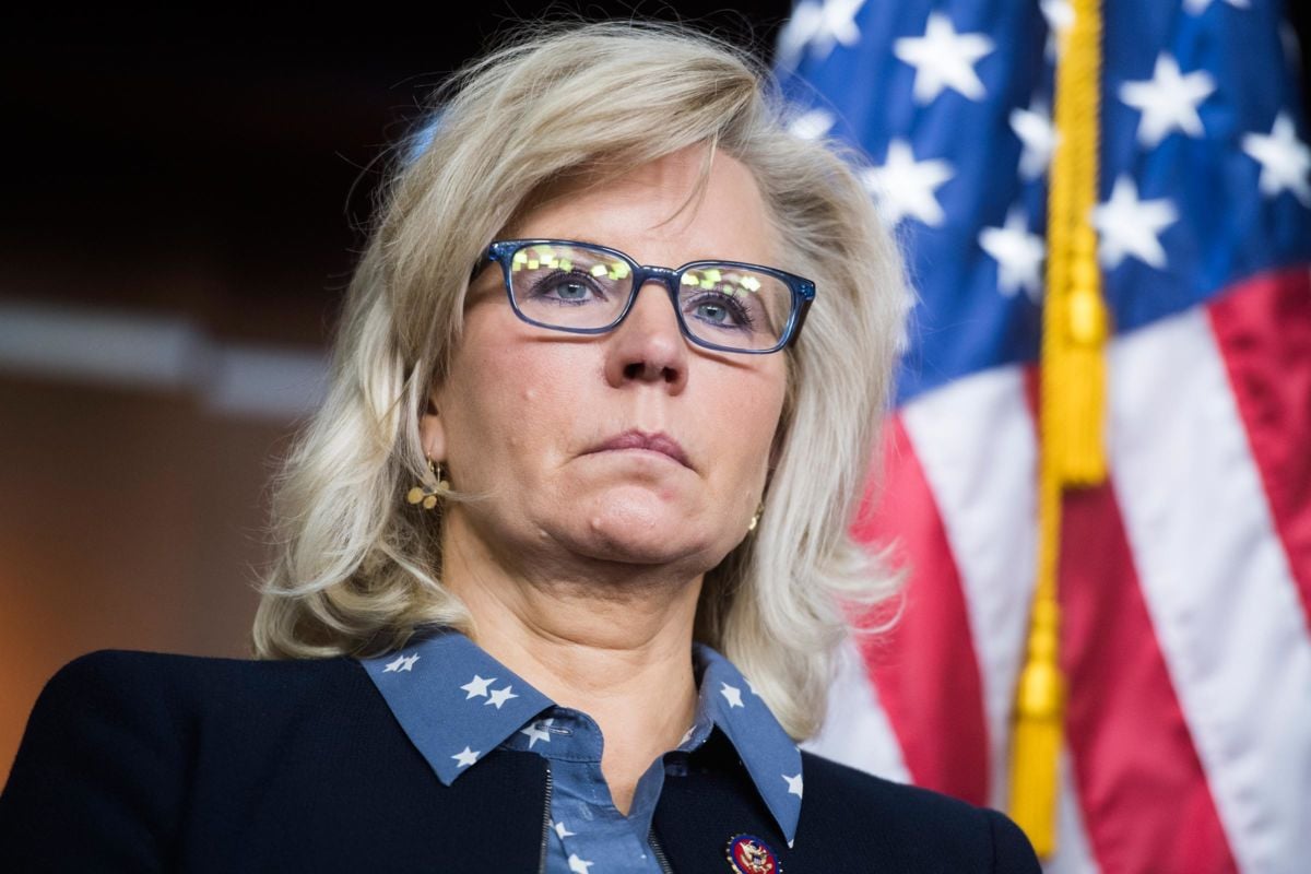 Liz Cheney stands in front of a U.S. flag